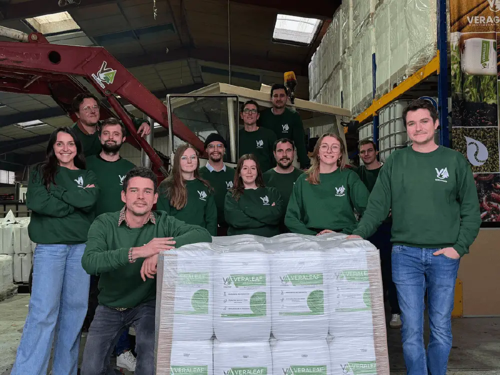 Les employés de la startup Veragrow possent devant une pallette de biostimulant à base de lombricompost à l'intérieur de l'usine de Val-de-Reuil